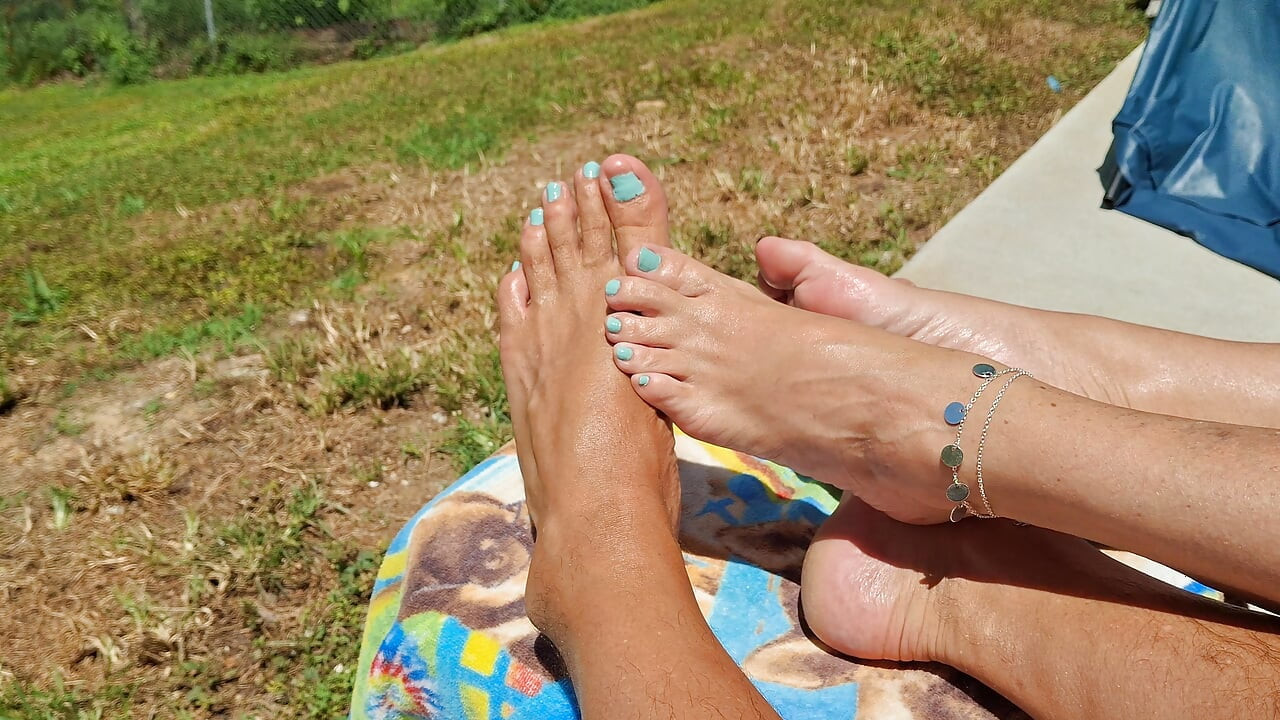Reiben unsere gebräunten, geölten füße zusammen in der sonne