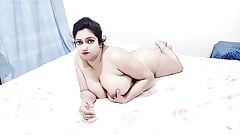 Mooi en mooi mollig meisje, volledig naakt, toont haar borsten op het bed