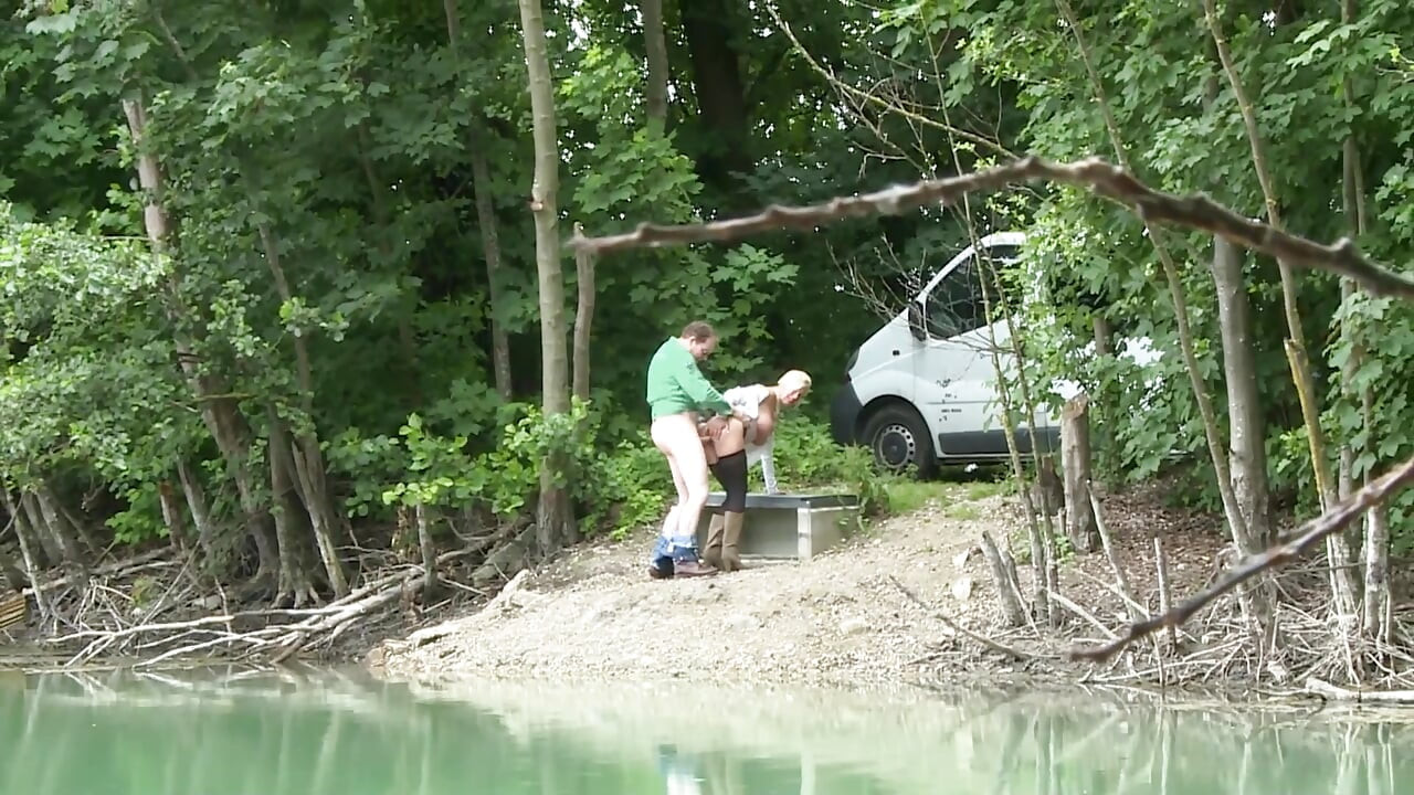 Une blonde sexy aux seins énormes chevauche une énorme bite au bord du lac