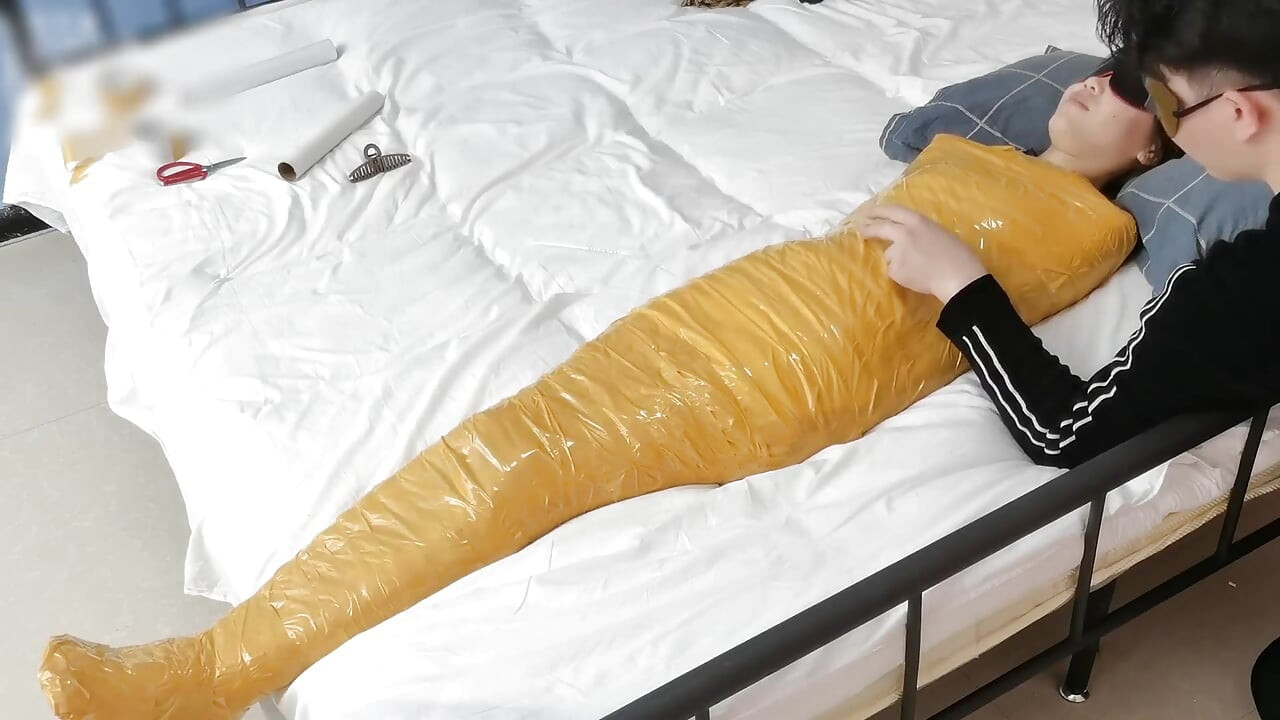 A Cute Barefoot Girlfriend Uses Tape to Bind Her Whole Body, Playing with Her Cute Bare Feet