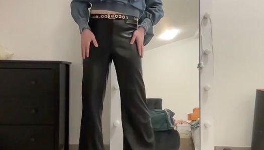Трансвестит в кожаных клешеных брюках и джинсевой блузке