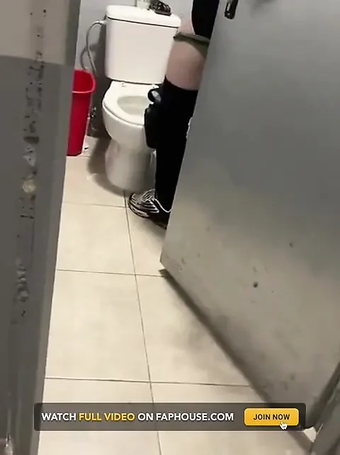 Un garçon ouvre une cabine carrée et surprend son ami en train de