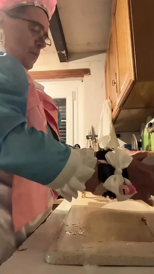 In a blue maid's outfit with pink bows to do the dishes.