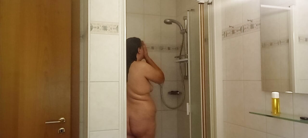 Echte vrouw die zachte buik doucht, natte huid