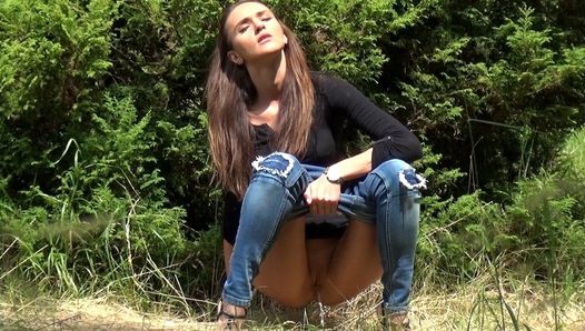 Grote lange pis in het gras voor brunette babe