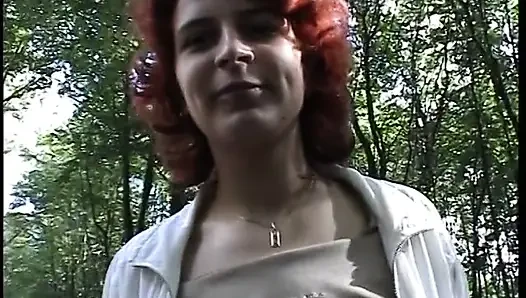 Redhead chick plays with her pussy outdoors