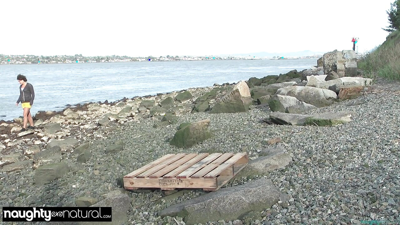 Frau mit silbernen Ohrringen masturbiert am Strand