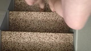Die Schlampe nackt in durchsichtigen Pantoletten im Treppenhaus