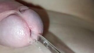 Chico joven inserta un tubo en la uretra de una pequeña polla