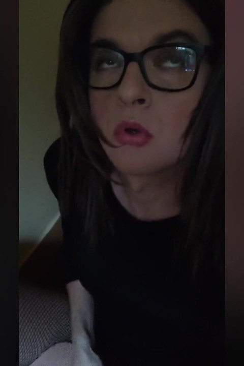 Trans žena u mrežastim čarapama na ružičastom krevetu