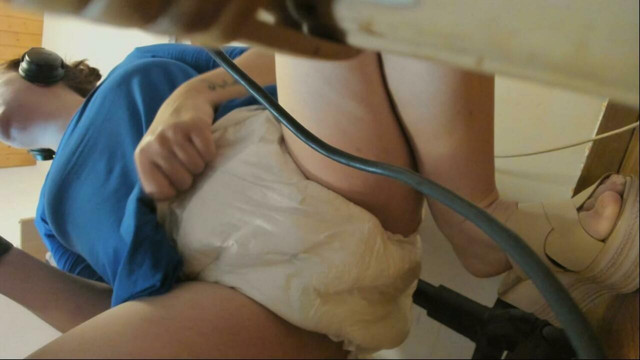 Girl with big dirty diaper works on the pc and pisses herself