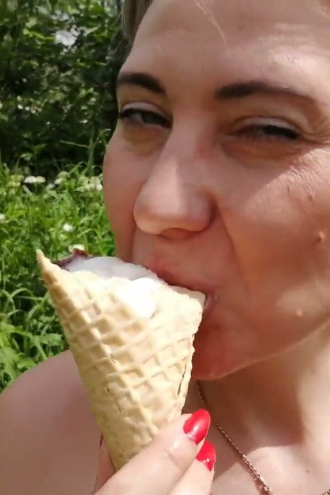 熟女吃冰淇淋并在草地上吹箫