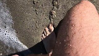 Promenade sur la plage nudiste en public et pisse