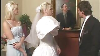 Blonde bruid met mooie tieten zuigt en neukt twee keiharde pikken in bed