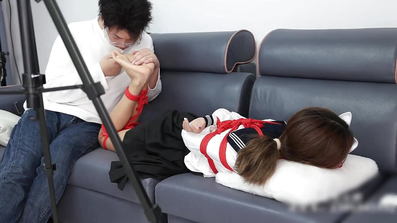 The Barefoot Girl Is Bound with Red Ropes, Tickling Her Feet, and Her Foot Fetishism