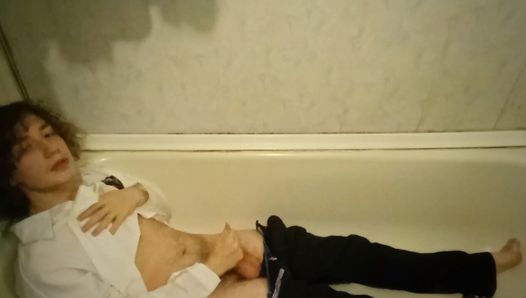 Ein Schuljunge masturbiert nach einem anstrengenden Tag müde im Badezimmer und hat dabei seine Kleidung an.