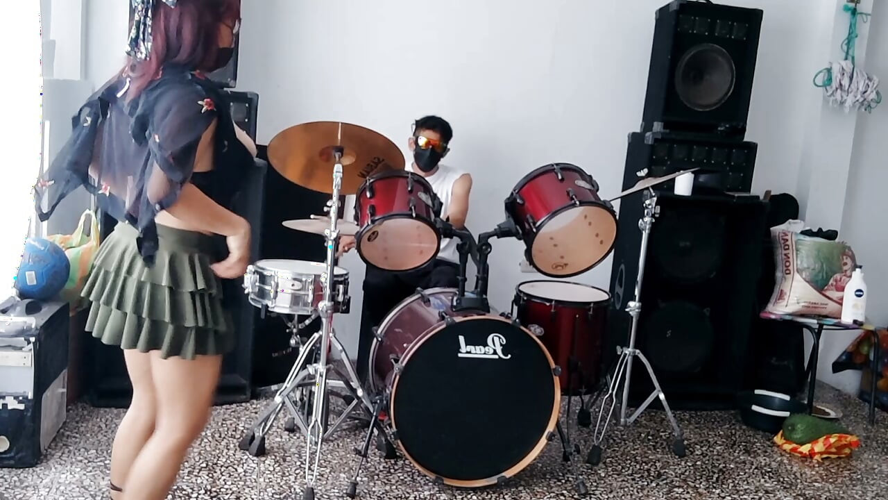Best female friend performs a sexy dance for her male friend while he plays the drums.