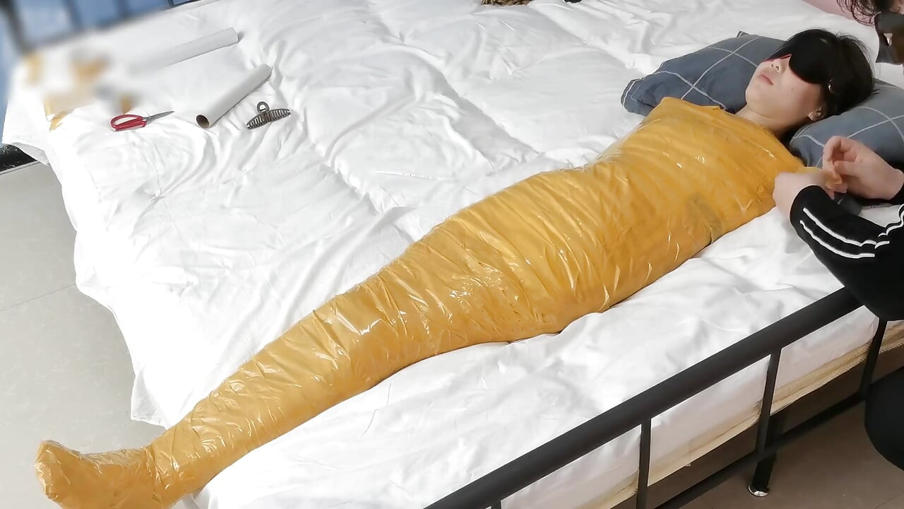 A Cute Barefoot Girlfriend Uses Tape to Bind Her Whole Body, Playing with Her Cute Bare Feet
