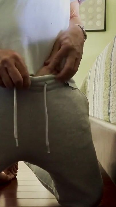 Un pantalon de survêtement gris se fait renfler et caresser