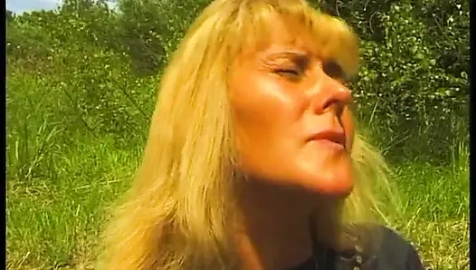 Cewek dewasa rambut pirang dengan memek berbulu bersenang-senang di luar ruangan