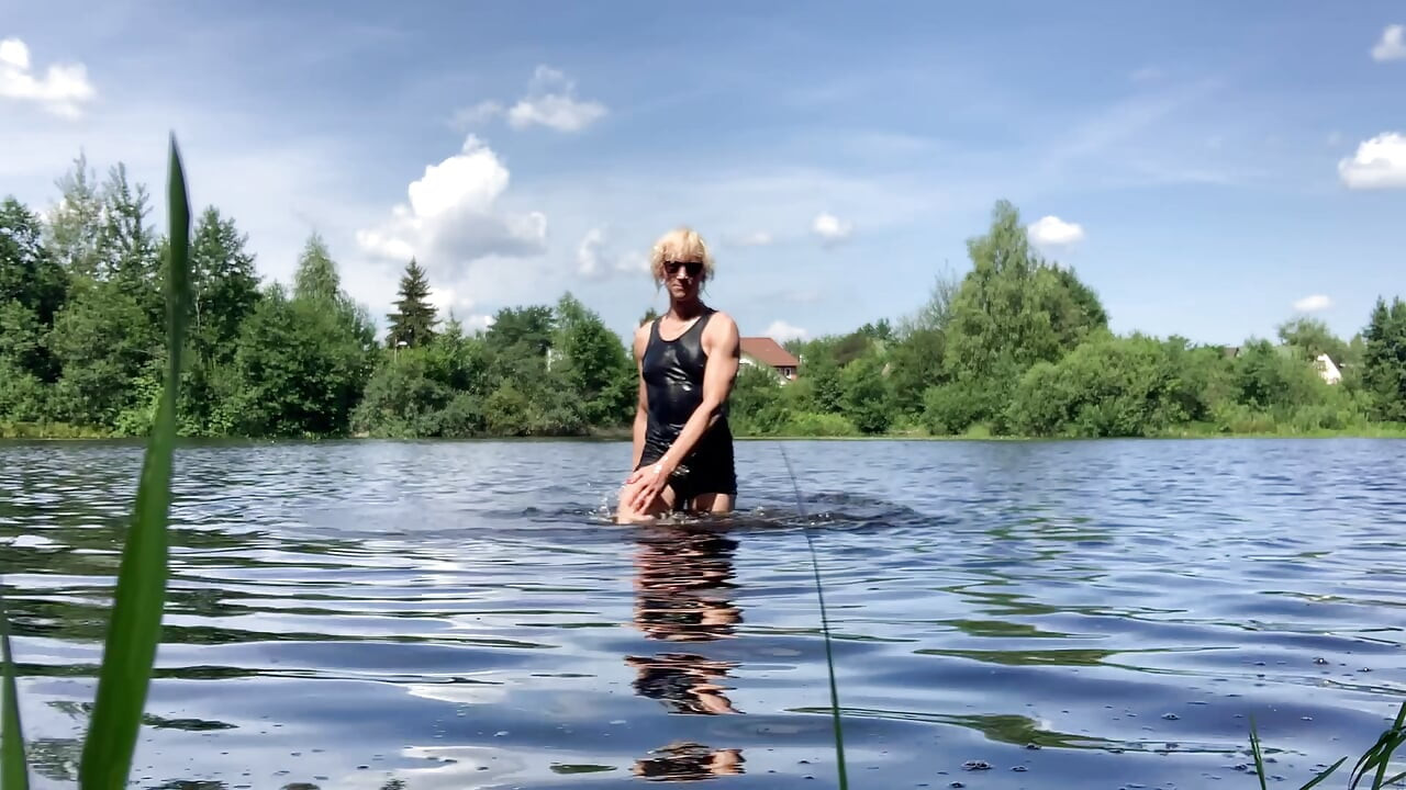 Trans djevojka Alexa Cosmic pliva i igra se u jezeru u crnoj kratkoj i plavoj majici