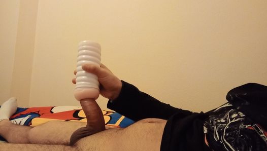 O jovem experimenta o novo brinquedo na cama massageando-o com a mão e grava-o como um vídeo.