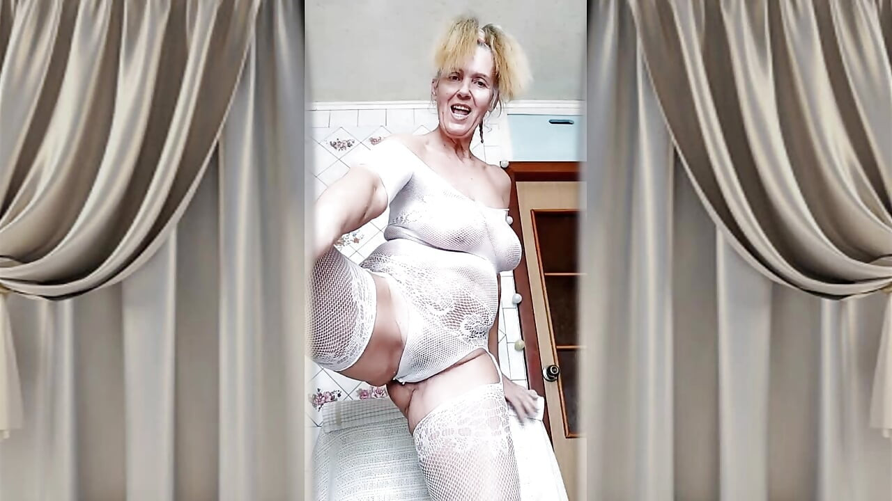 Hot husmor Lukerya flørter i en åpen gjennomsiktig hvit jumpsuit på kjøkkenet 2
