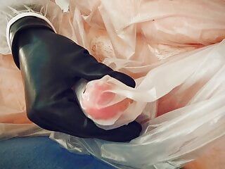 Être dur en posant dans une robe en plastique et des gants en latex