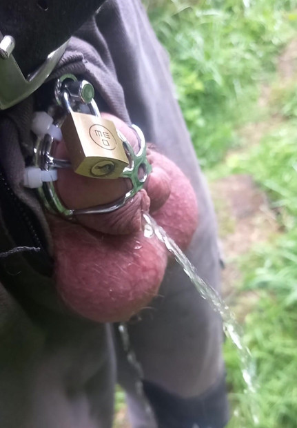 Cuckold with helpless small cock and chastity cage pisses outdoors