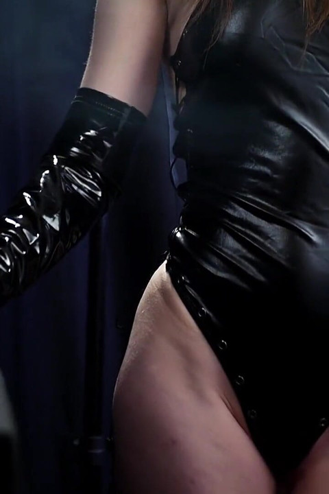 Brunetă sexy care fumează într-o ținută de latex elegantă, vibe dominant și încrezător