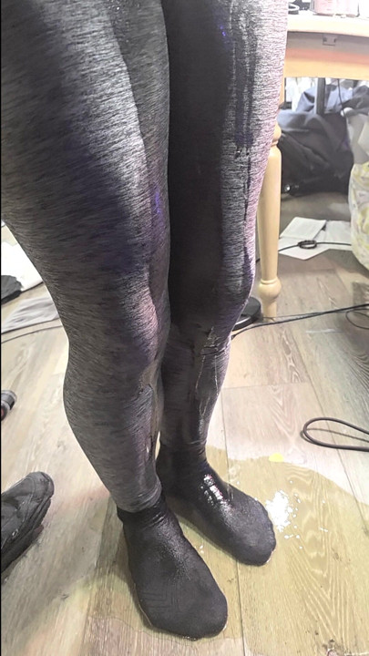 Gray leggings and sock puddle on vinyl floor