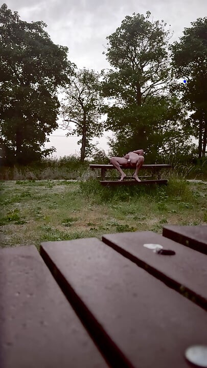 Naked in park standing on benches naked vehicles pass close