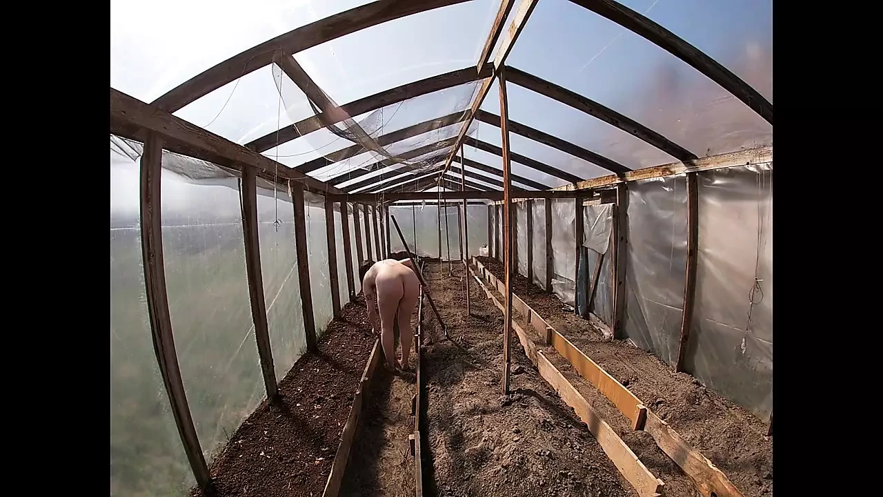 Nude house wife working in the greenhouse
