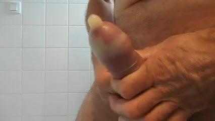 Handjob and big cumshot in a condom .