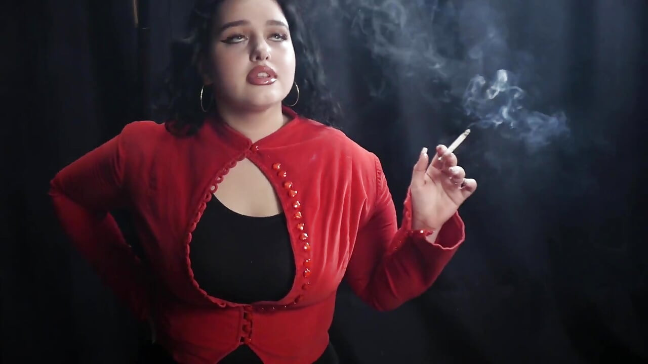 丰满的黑发女郎穿着红色开衣抽烟