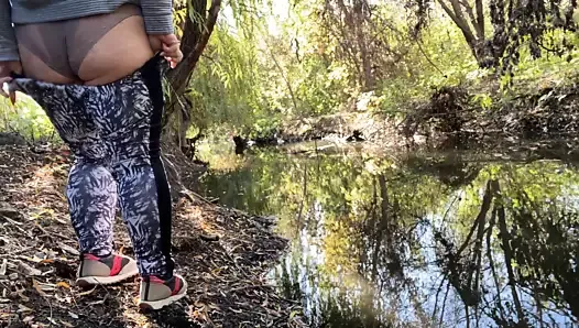 MILF dressed in leggings pissing in the river