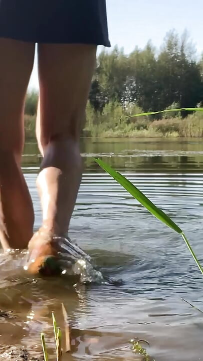 Trans djevojka pliva u jezeru u plavoj sportskoj haljini. Wetllok trans djevojka mokra.