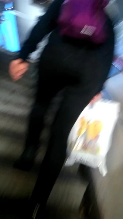 Young woman in tight black pants who goes up the stairs