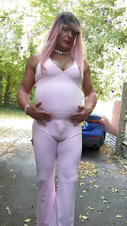 Crossdresser kellycd2022 u ružičastom kombinezonu i štiklama