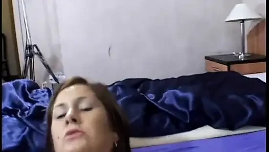 Brünette nimmt schwanz in ihre enge muschi, während sie auf dem bett liegt