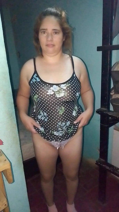 She pulls up her floral dress from the front to show us her purple thong