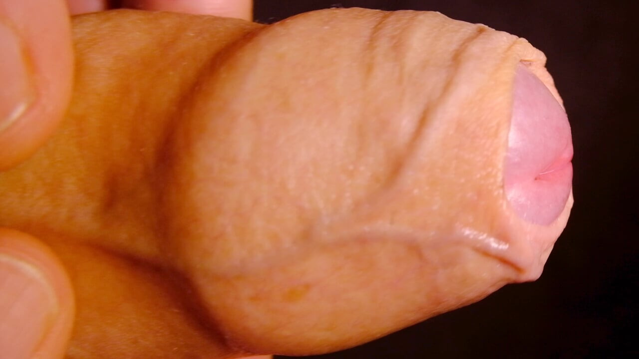 Very Close up on the tip of his uncut penis as he plays with his foreskin and show bell-end
