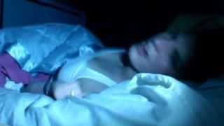 Sexy brunette masturbeert op bed in het donker