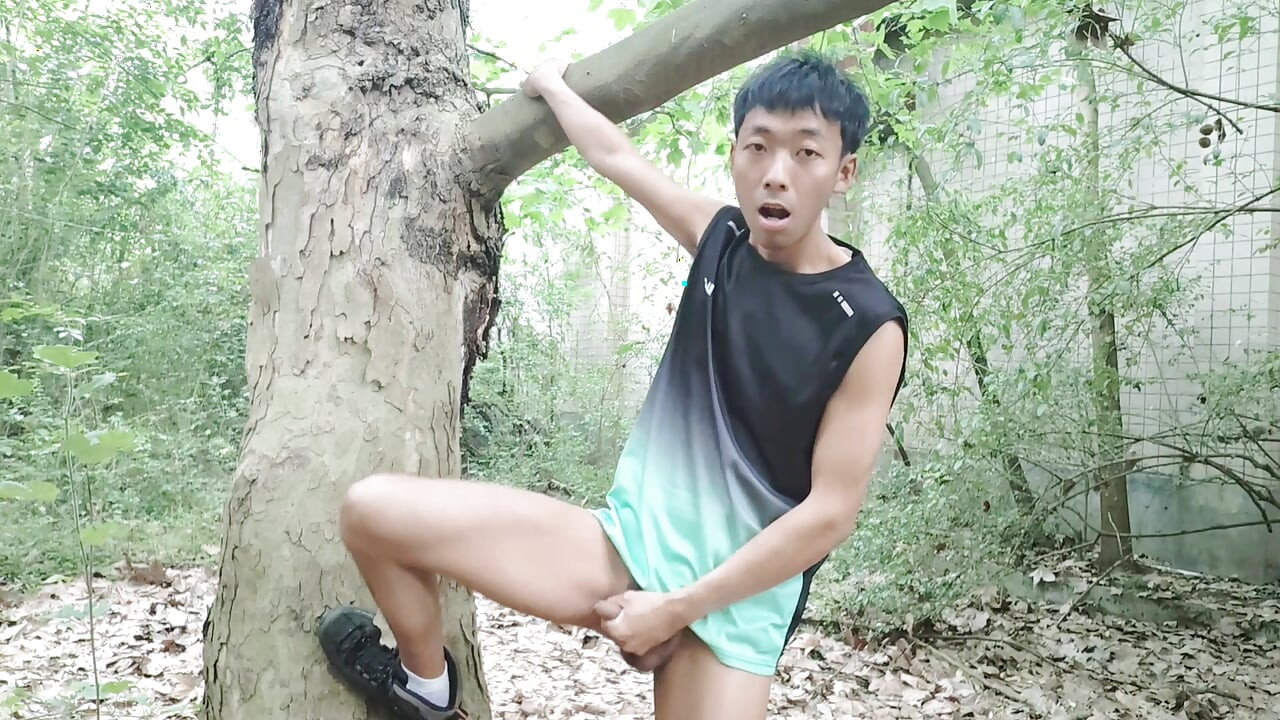 A mischievous Asian boy masturbates, moaning and ejaculating in the atrium garden of an abandoned hotel