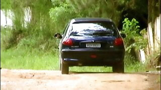 Un jeune couple excité baise dans une voiture au milieu de la route