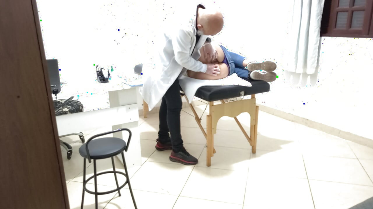 Proctologist performs anal exam on constipated patient.