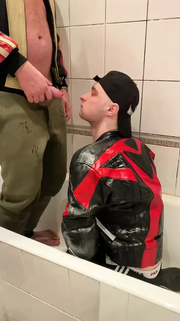 Grande homem de jaqueta de couro mijando em moto motociclista de couro