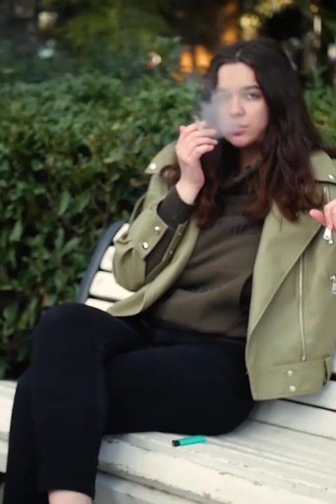 Jovem morena está dando um passeio sem pressa com cigarro Allwhite de 120mm