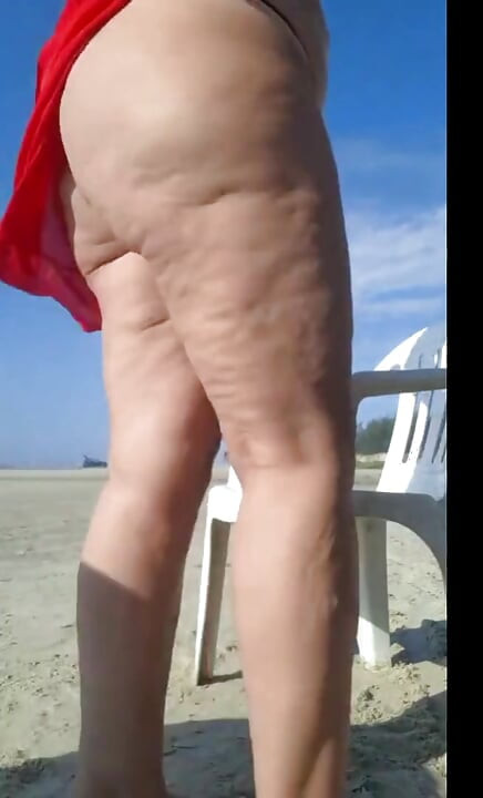 Hot crown sunbathing on the beach in transparent micro bikini