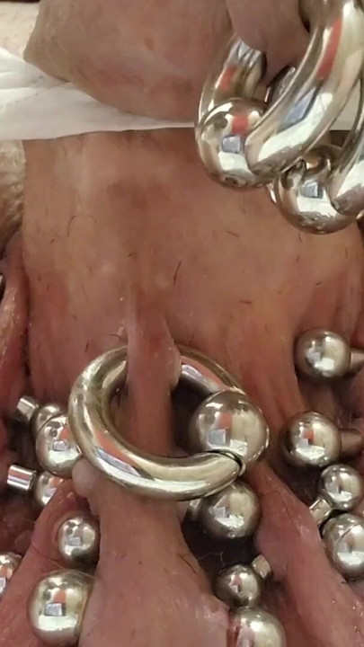 Stretching 8 gauge piercings to 6 gauge on scrotum with pre cum | Clip 1